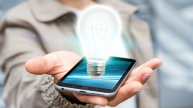 Cep telefonu parlak ampul tutan işadamı