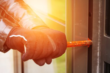 Bir evde kırma deri ceket giyen hırsız