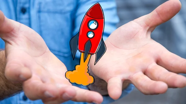 Businessman holding red hand drawn rocket in his hand