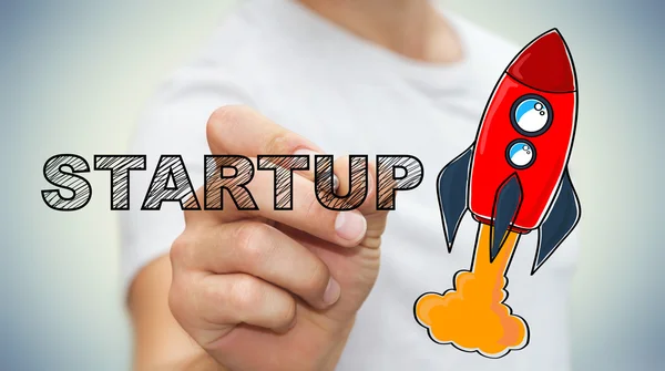 Geschäftsmann entwirft Startup-Text und rote Rakete mit Stift — Stockfoto