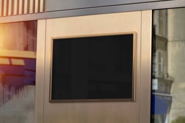 Metal bronz çerçeve sokak modelinde asılı. Duvardaki bir reklam panosunun şablonu 3 boyutlu güneş ışığıyla yıkanmış.