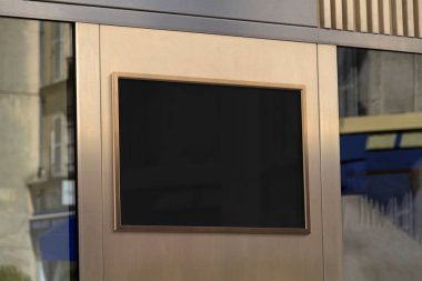 Metal bronz çerçeve sokak modelinde asılı. Duvardaki bir reklam panosunun şablonu 3 boyutlu güneş ışığıyla yıkanmış.