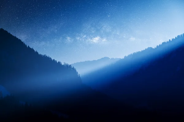 Млечный путь над голубой горой — стоковое фото