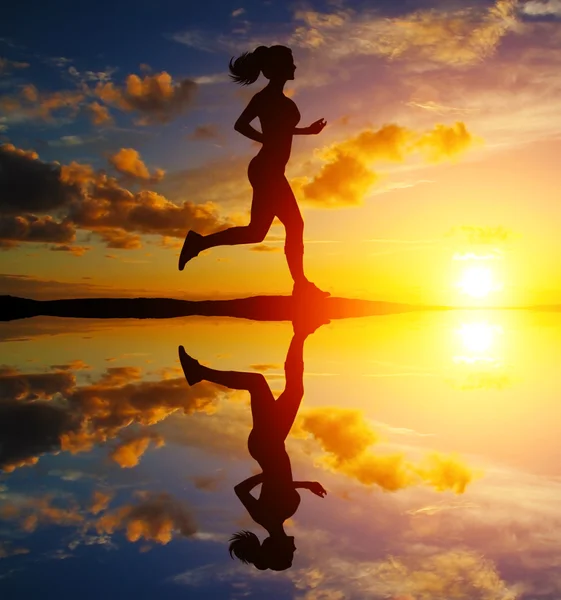 Correndo menina ao pôr do sol silhueta — Fotografia de Stock