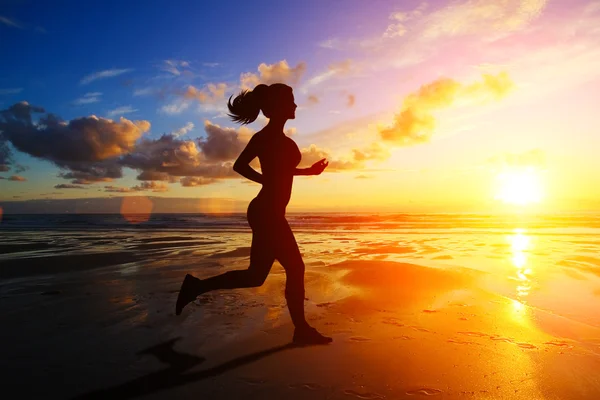 Running girl at sunset silhouette — Stock Photo, Image