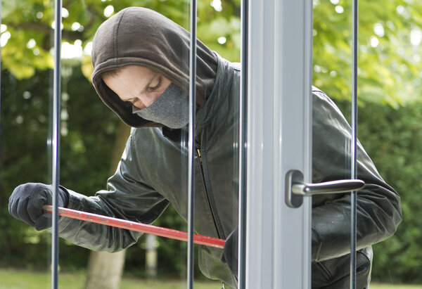 Burglar breaking in a house