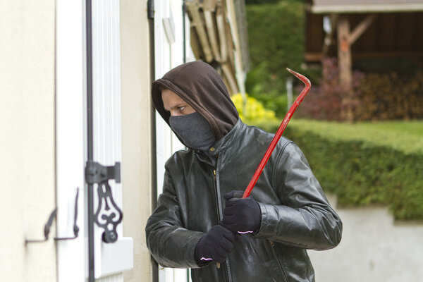 Burglar breaking in a house