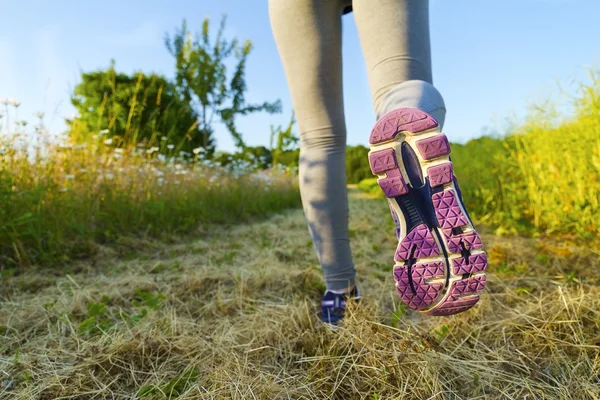 Donna che corre in un campo — Foto Stock