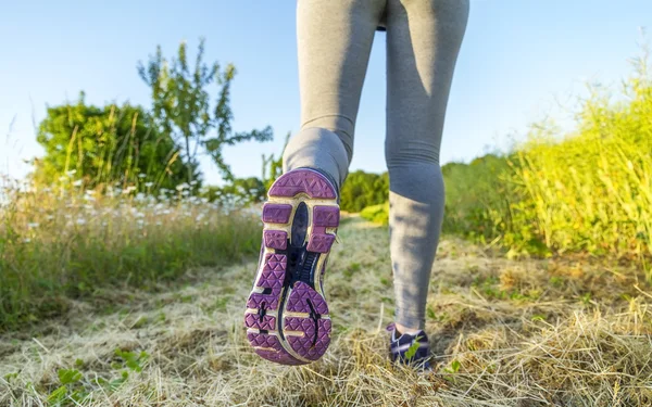 Donna che corre in un campo — Foto Stock