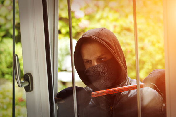 Burglar breaking in a house