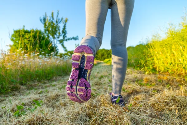 Donna che corre al tramonto in un campo — Foto Stock