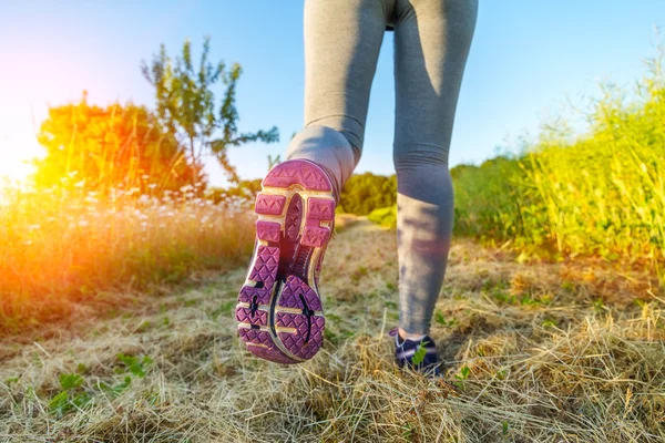 Donna che corre al tramonto in un campo — Foto Stock