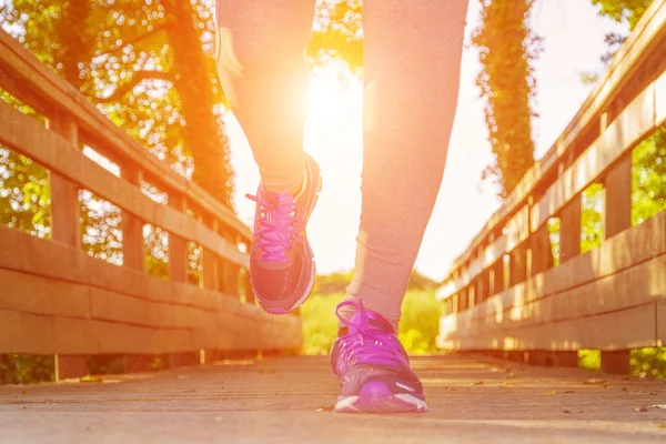 Donna che corre al tramonto in un campo — Foto Stock