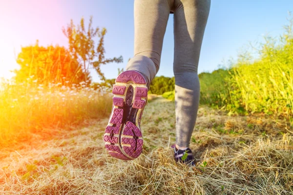 Donna che corre al tramonto in un campo — Foto Stock