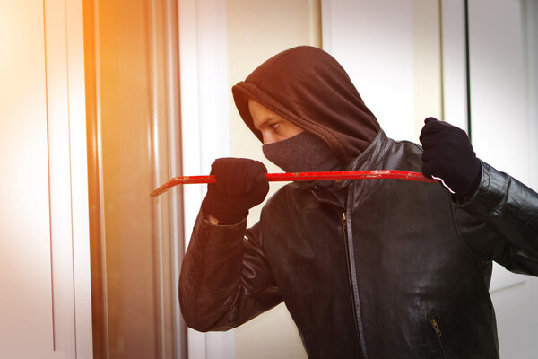 Burglar breaking in a house