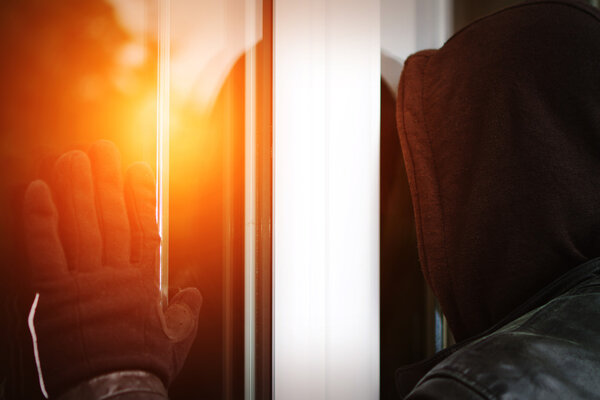 Burglar breaking in a house