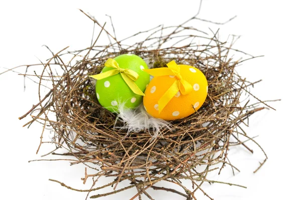Huevos coloridos de Pascua en el nido sobre un fondo blanco — Foto de Stock