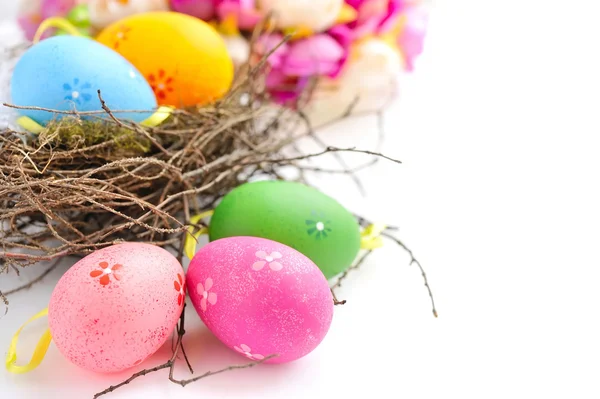 Kleurrijke Pasen eieren in nest op een witte achtergrond — Stockfoto