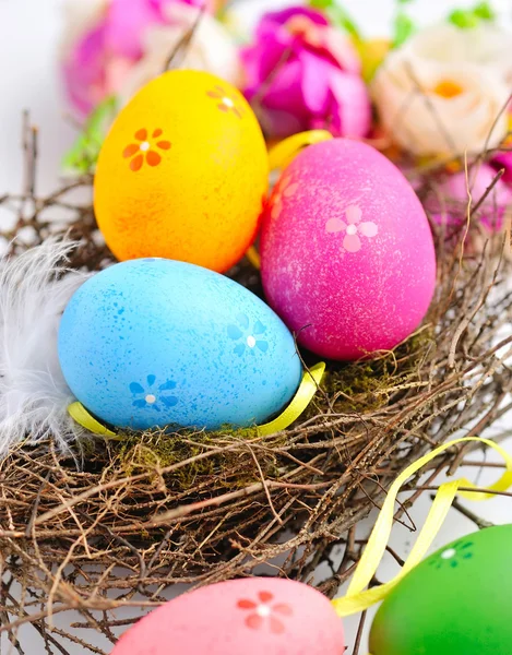 Kleurrijke Pasen eieren in nest op een witte achtergrond — Stockfoto
