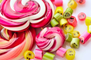 Renkli şekerler ve beyaz bir arka plan üzerinde lolipop