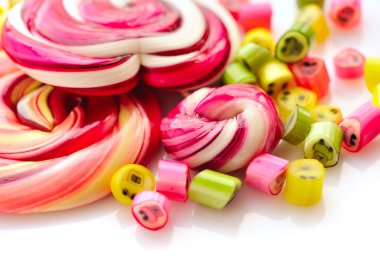 Renkli şekerler ve beyaz bir arka plan üzerinde lolipop