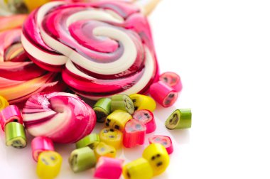 Renkli şekerler ve beyaz bir arka plan üzerinde lolipop