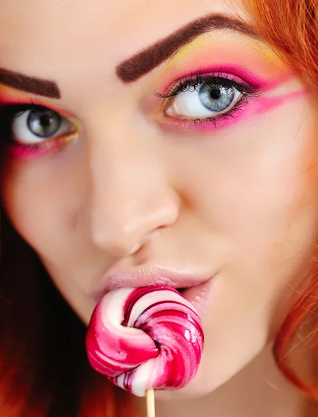 Mooie sexy vrouw likken een roze lolly — Stockfoto