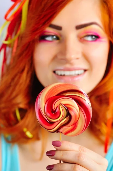 Ljusa lollipop i händerna på en vacker flicka. Fokusera på lollipop Royaltyfria Stockbilder