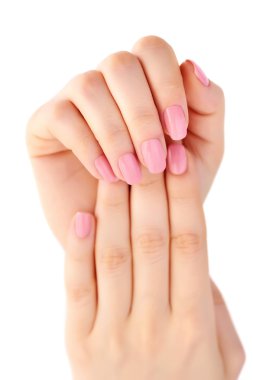 İzole üzerinde beyaz arka plan üzerinde pembe manikür ile genç bir kadın elinde closeup çivi