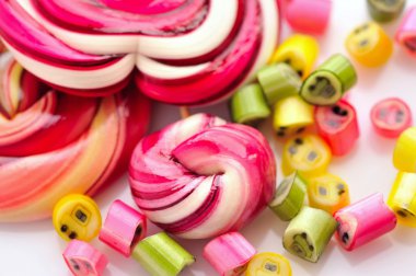 Renkli şekerler ve beyaz bir arka plan üzerinde lolipop