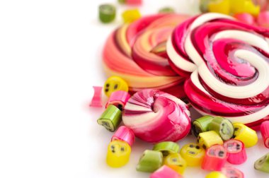 Renkli şekerler ve beyaz bir arka plan üzerinde lolipop