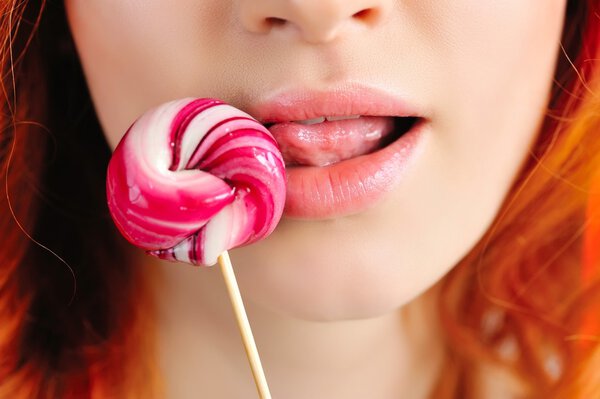 Крупный план сексуально-красные губы с леденцом
