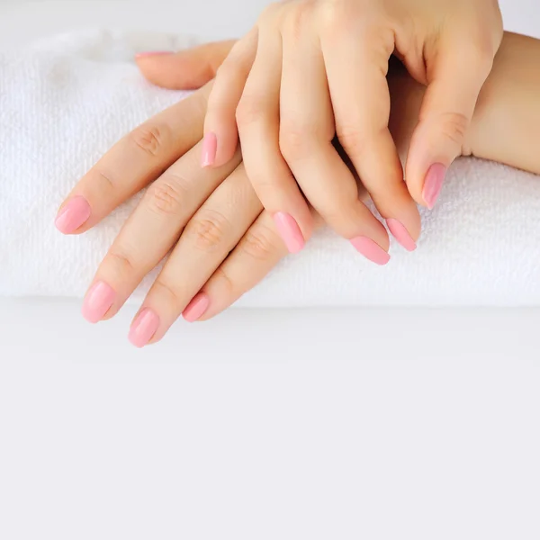 Hands of a woman with pink manicure are on a towel — Stock Photo, Image