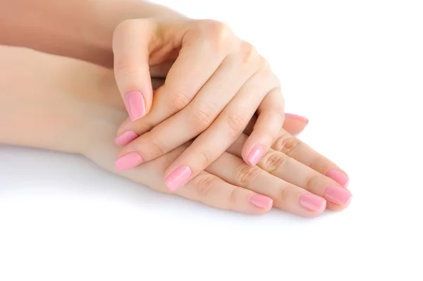 Primo piano di mani di una giovane donna con manicure rosa su unghie su sfondo bianco — Foto Stock