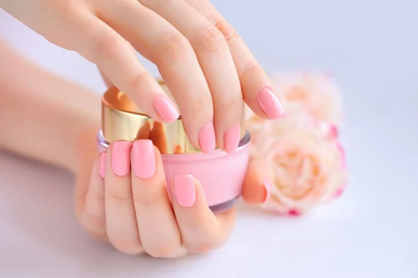 Handen van een vrouw met roze manicure met room — Stockfoto