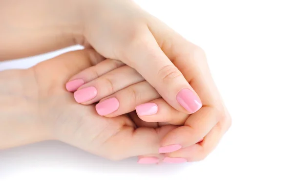 Closeup των χεριών του μια νεαρή γυναίκα με ροζ μανικιούρ στα νύχια ενάντια σε λευκό φόντο — Φωτογραφία Αρχείου