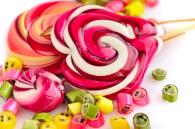 Renkli şekerler ve beyaz bir arka plan üzerinde lolipop