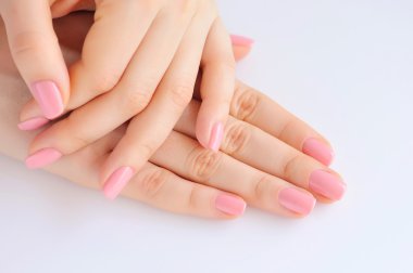 Elinde çivi beyaz arka plan üzerinde pembe manikür genç bir kadınla closeup