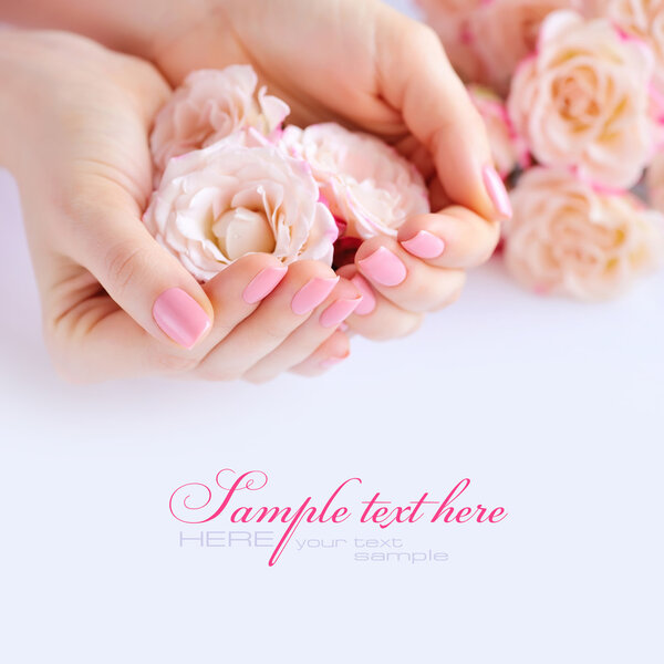 Hands of a woman with pink manicure on nails  and roses