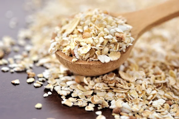 Oat flakes on a wooden spoon close-up — Stock Photo, Image