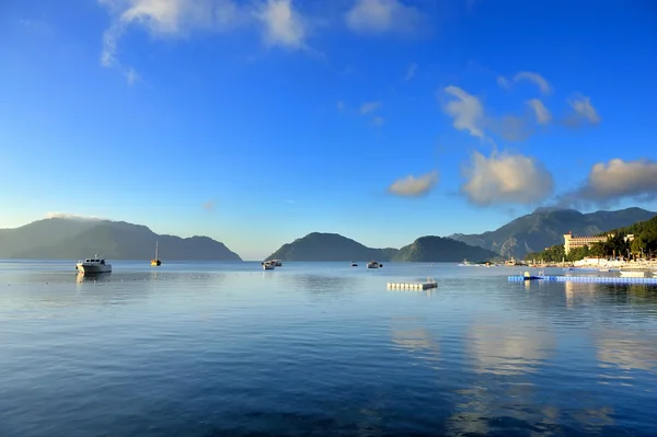 Çok güzel bir sabah deniz manzarası tekneler ve dağ içinde belgili tanımlık geçmiş — Stok fotoğraf