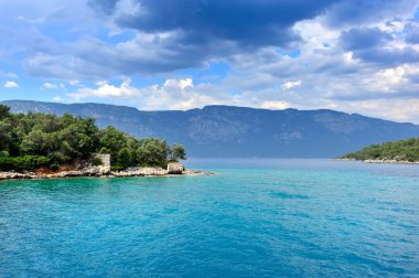 Ada ve eski bina kalıntıları ile güzel deniz manzarası. Ege Denizi. Türkiye