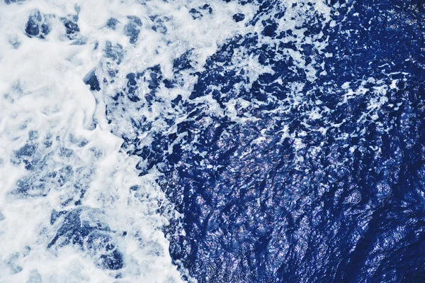 Blaue Meerwasseroberfläche in Bewegung mit Schaum — Stockfoto