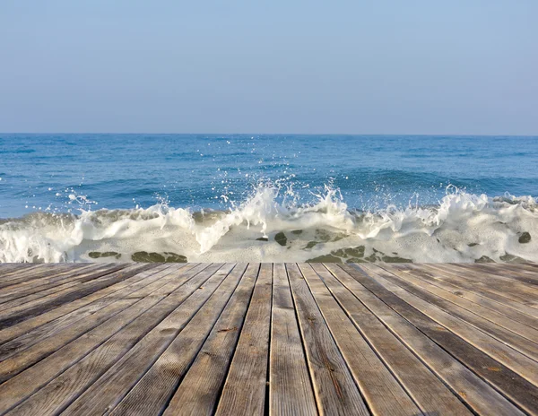 Zeegezicht met het runnen van de golven. Het uitzicht vanaf de houten pier — Stockfoto