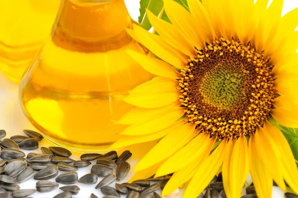 Zonnebloemolie met bloemen en door zaad op witte achtergrond — Stockfoto