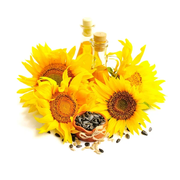 Un tazón pequeño de semillas de girasol, y flores de girasol con botella de aceite sobre un fondo blanco —  Fotos de Stock