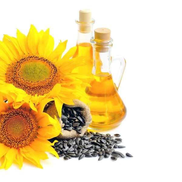 Small bag with sunflower seeds and flowers and a bottle of sunflower oil — Stock Photo, Image