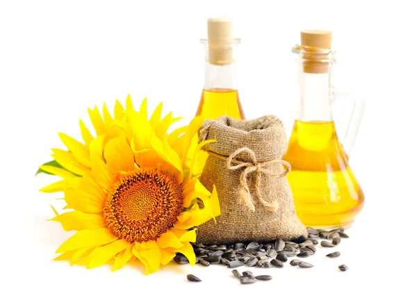 Small bag with sunflower seeds and flowers and a bottle of sunflower oil — Stock Photo, Image