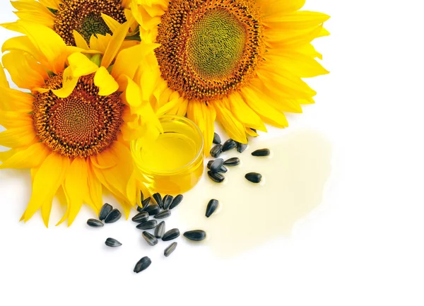 Olio di girasole con fiori e semi su sfondo bianco — Foto Stock