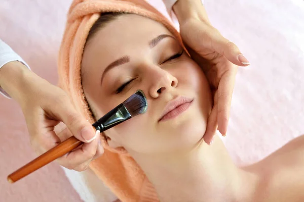 面部剥皮面膜 温泉美容治疗 在温泉沙龙接受美容师的面部护理的妇女 — 图库照片